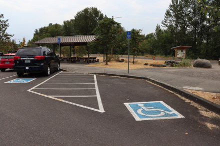 Two accessible parking spaces, picnic shelter and kiosk at parking lot